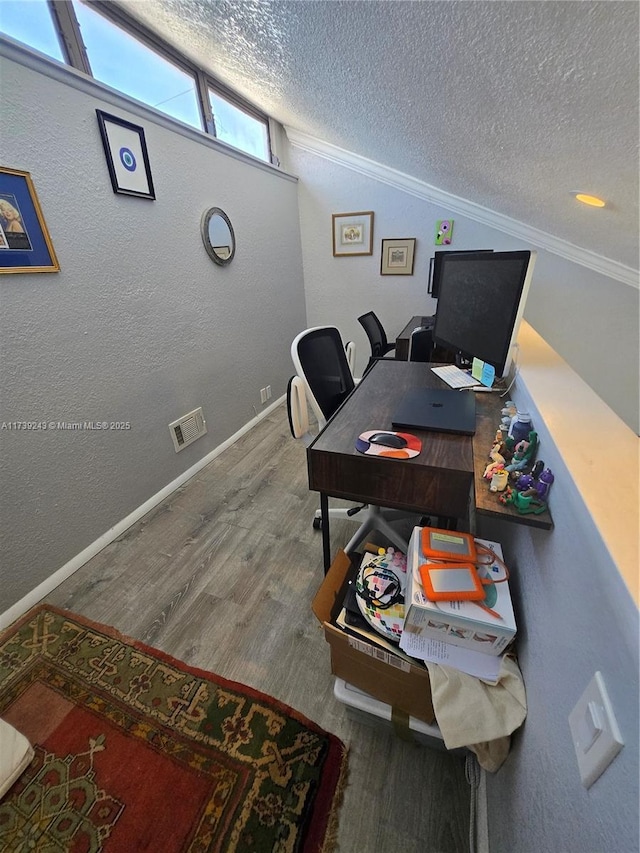 home office with hardwood / wood-style flooring, crown molding, vaulted ceiling, and a textured ceiling