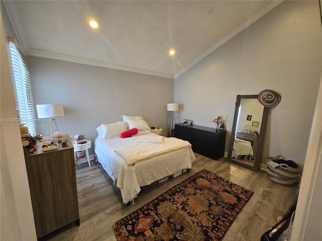 bedroom with ornamental molding, vaulted ceiling, and wood-type flooring