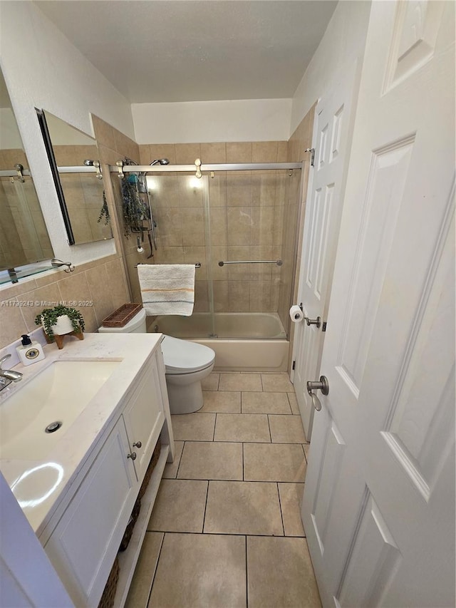 full bathroom featuring toilet, tasteful backsplash, vanity, enclosed tub / shower combo, and tile patterned flooring