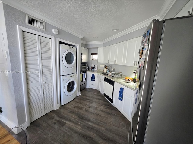 kitchen featuring white cabinetry, ornamental molding, stacked washer / drying machine, and stainless steel fridge