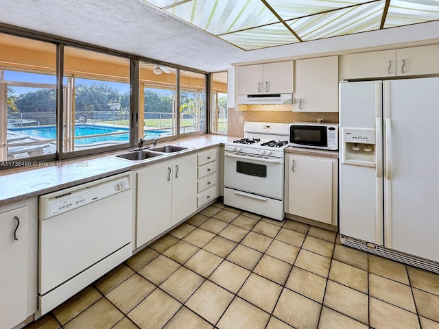 kitchen featuring light tile patterned flooring, sink, white cabinetry, a textured ceiling, and white appliances