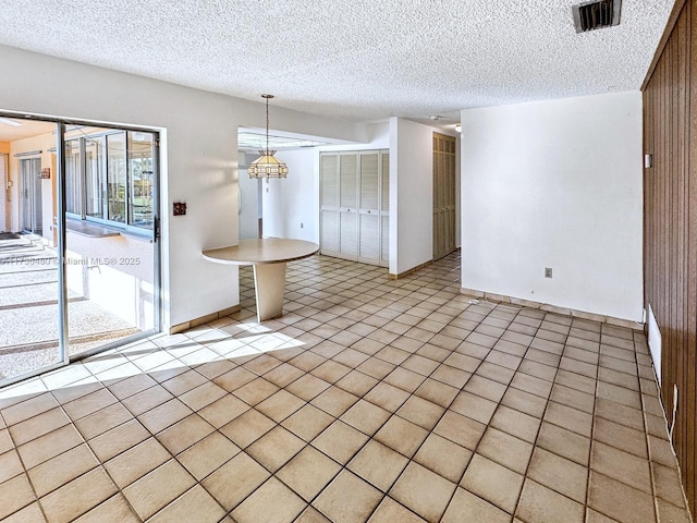 unfurnished dining area with light tile patterned floors and a textured ceiling