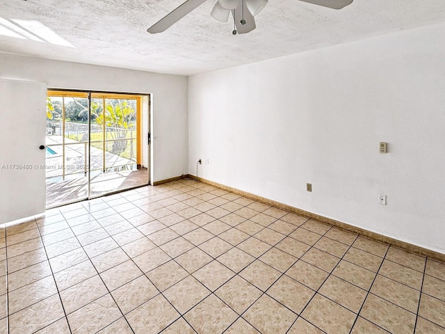 empty room with ceiling fan and a textured ceiling