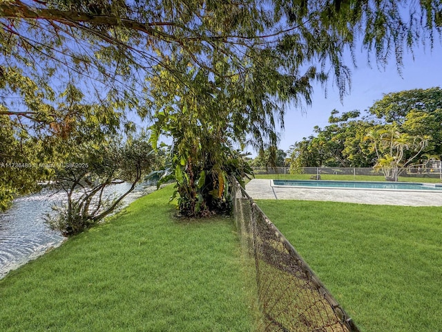 view of yard featuring a fenced in pool and a water view