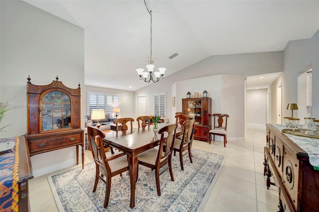 tiled dining room featuring vaulted ceiling and an inviting chandelier