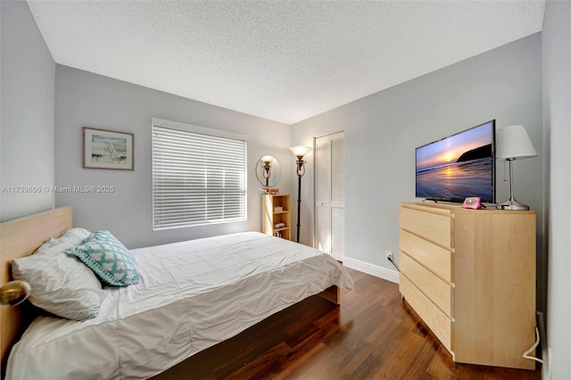 bedroom featuring a textured ceiling, dark hardwood / wood-style flooring, and a closet