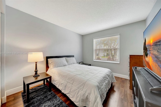 bedroom featuring dark wood-type flooring and a textured ceiling