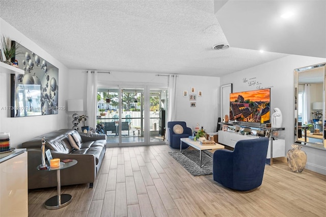 living room featuring a textured ceiling and light wood-type flooring