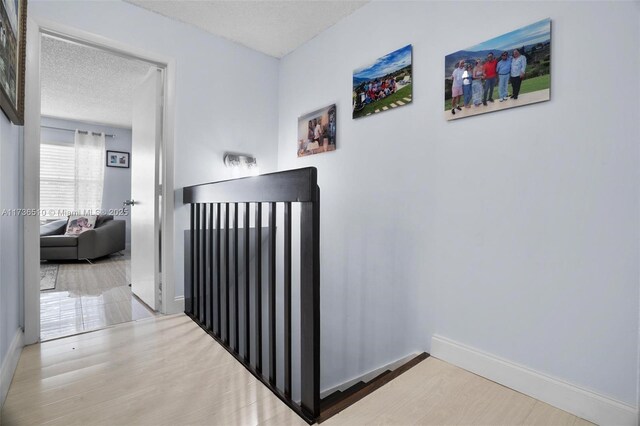 corridor featuring hardwood / wood-style flooring and a textured ceiling