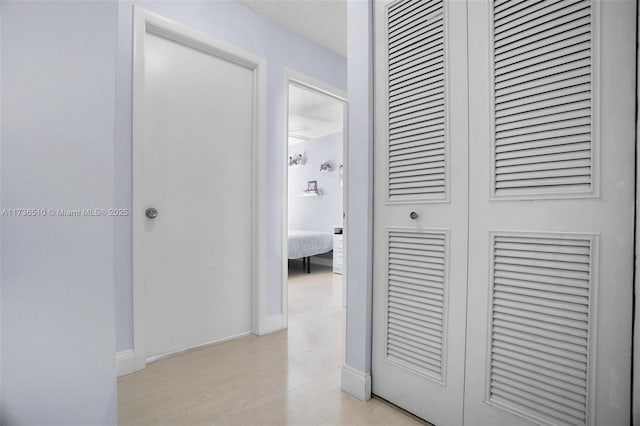 hallway featuring a textured ceiling and light wood-type flooring