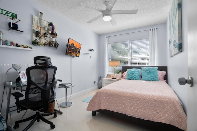 bedroom with ceiling fan, a textured ceiling, and light hardwood / wood-style flooring