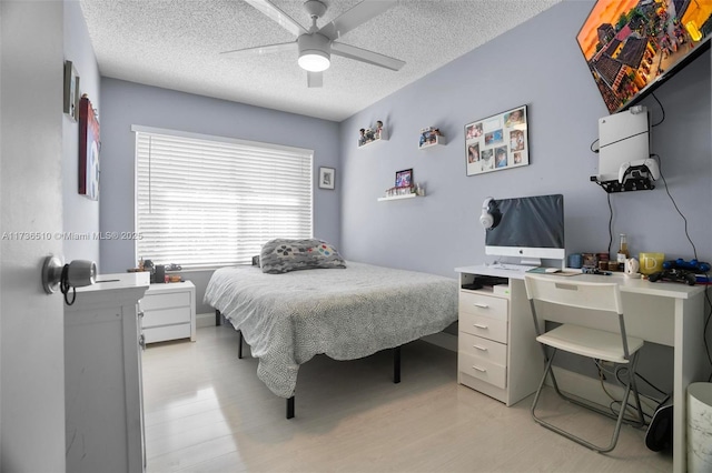 bedroom featuring ceiling fan, light hardwood / wood-style floors, and a textured ceiling