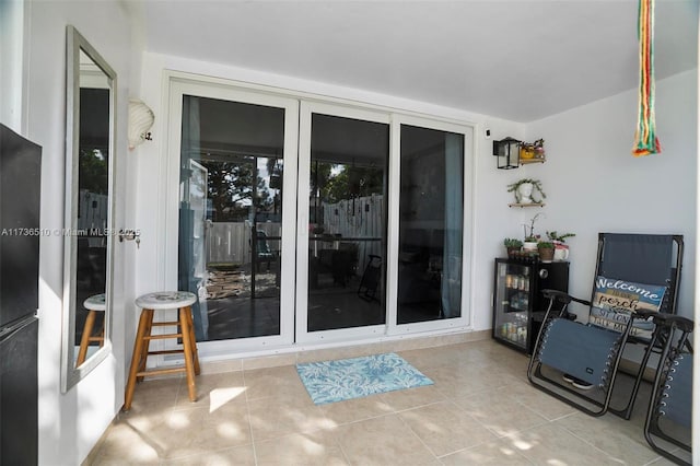 doorway to property featuring beverage cooler and a patio