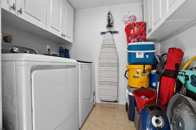 laundry room featuring cabinets, washer and dryer, and light tile patterned floors