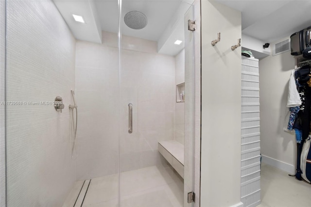 bathroom with an enclosed shower and tile patterned floors