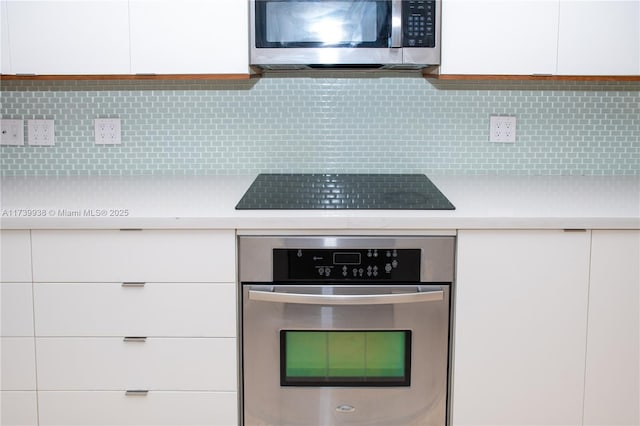 kitchen featuring appliances with stainless steel finishes, white cabinets, and backsplash