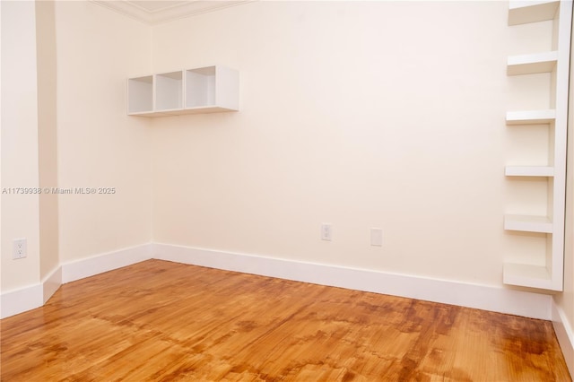 spare room with hardwood / wood-style floors and ornamental molding