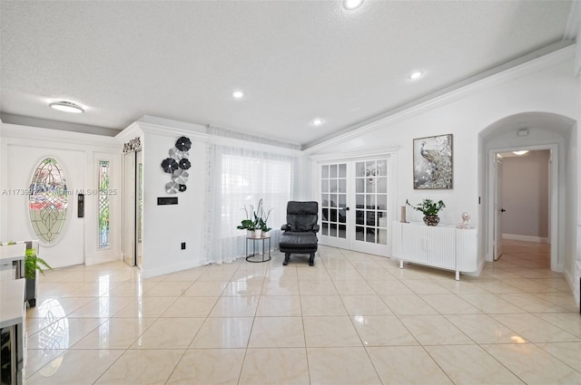 living area featuring light tile patterned floors, french doors, and a textured ceiling