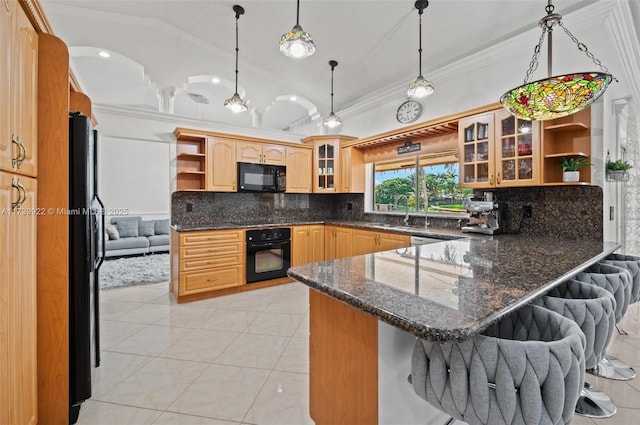 kitchen with kitchen peninsula, decorative light fixtures, black appliances, dark stone countertops, and a kitchen breakfast bar