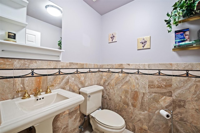 bathroom featuring tile walls, sink, and toilet