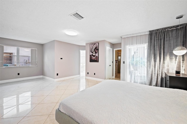 tiled bedroom featuring a textured ceiling