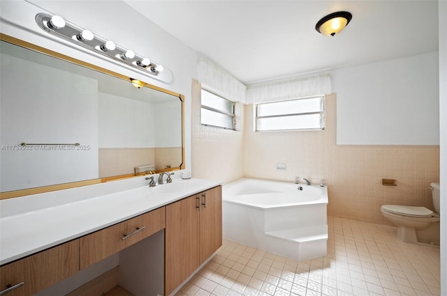 bathroom with tile walls, vanity, a tub to relax in, tile patterned flooring, and toilet