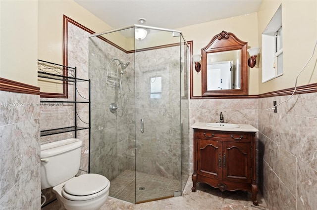 bathroom with vanity, tile walls, toilet, and a shower with door