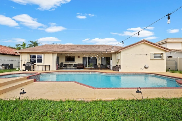 view of pool with an in ground hot tub, area for grilling, and a patio area