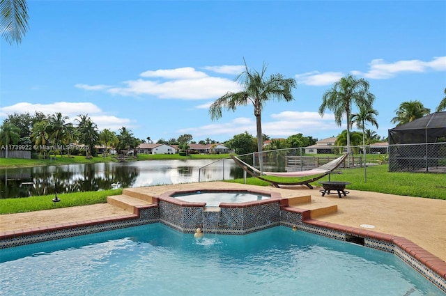 view of swimming pool with a patio area, a water view, a yard, and an in ground hot tub