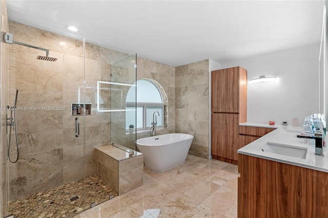 bathroom with shower with separate bathtub, tile walls, and vanity