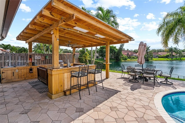 view of patio / terrace featuring a water view and an outdoor bar