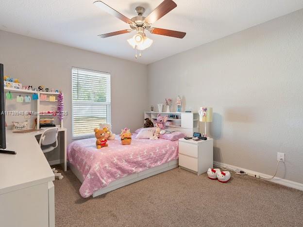 bedroom featuring light colored carpet and ceiling fan