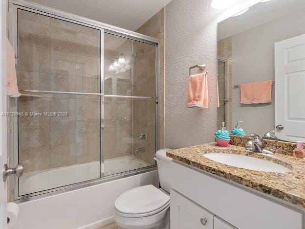 full bathroom featuring vanity, bath / shower combo with glass door, and toilet