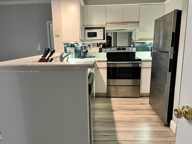 3145 NE 184th St Unit 5302, Aventura, FL 33160 - kitchen with light hardwood / wood-style flooring, ornamental molding, kitchen peninsula, stainless steel appliances, and white cabinets