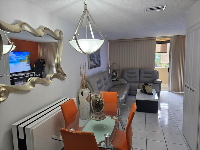 tiled dining area featuring a textured ceiling