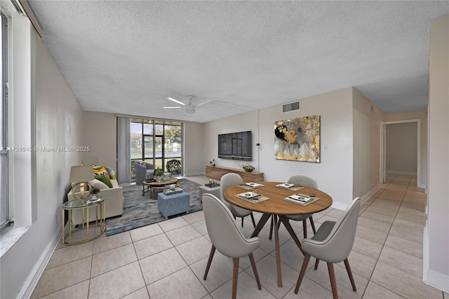 tiled dining space featuring a textured ceiling and ceiling fan