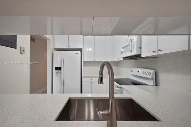 kitchen featuring white cabinetry, white appliances, sink, and light stone counters