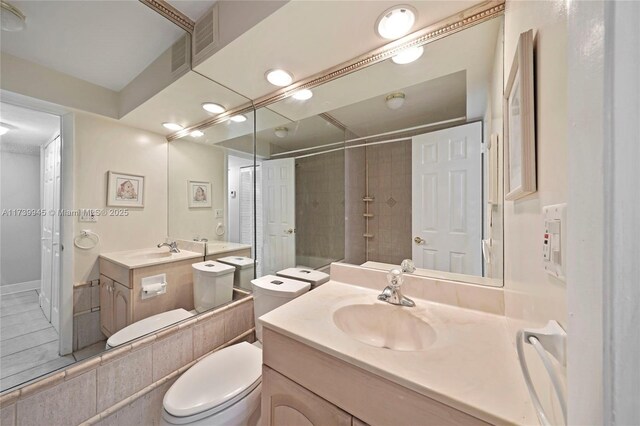 bathroom featuring vanity, toilet, and tiled shower