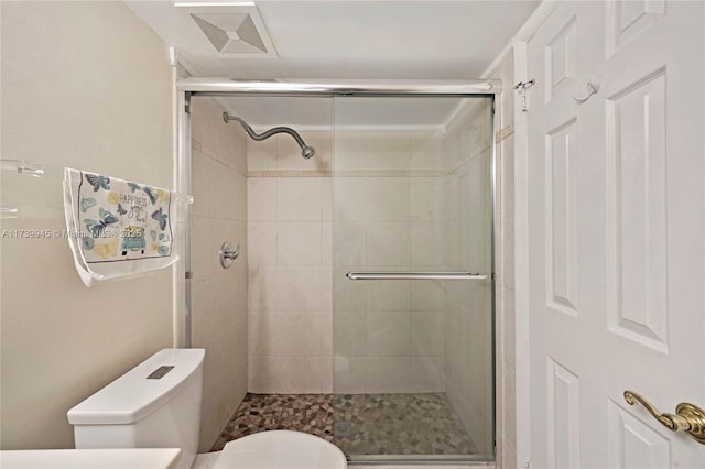 bathroom featuring walk in shower and toilet