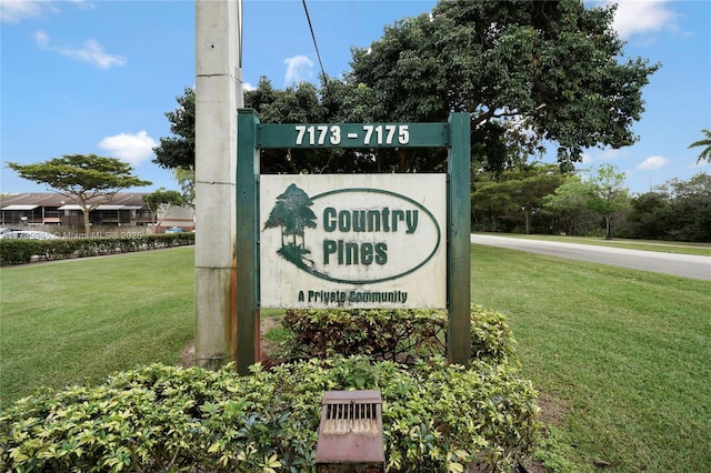 community sign featuring a yard