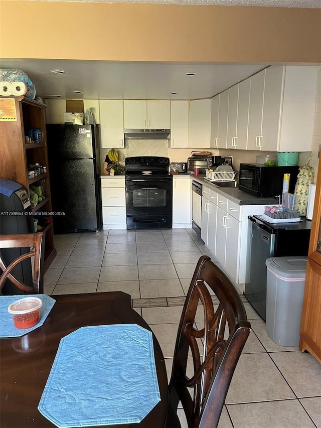 kitchen featuring light tile patterned floors, white cabinets, and black appliances