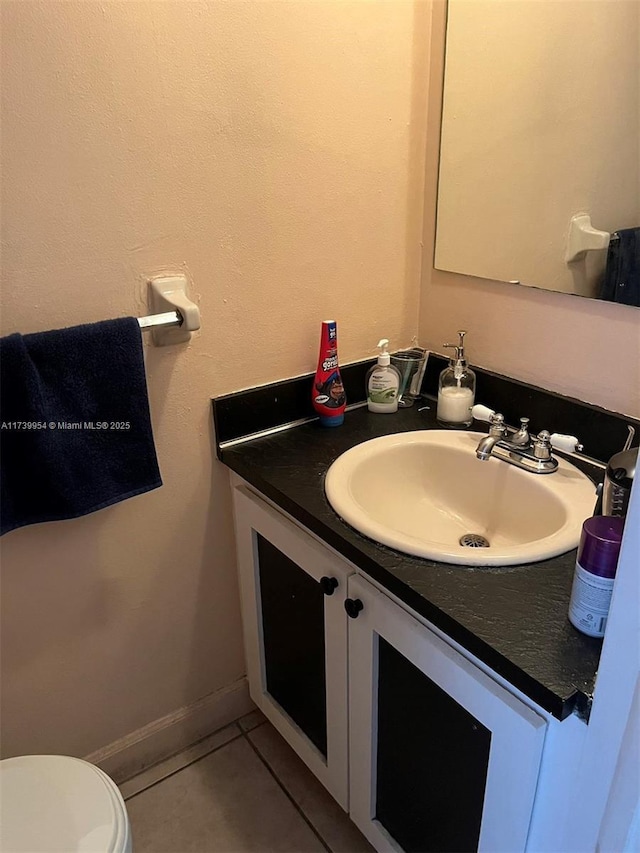 bathroom featuring vanity, tile patterned floors, and toilet