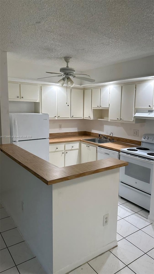 kitchen featuring sink, white appliances, a textured ceiling, light tile patterned floors, and ceiling fan