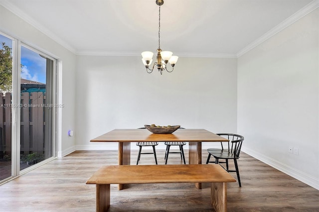 dining room featuring crown molding, wood-type flooring, and a chandelier