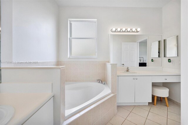 bathroom featuring tile patterned flooring, vanity, and tiled tub