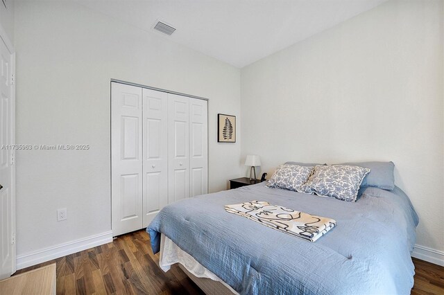 bedroom featuring dark wood-type flooring and a closet