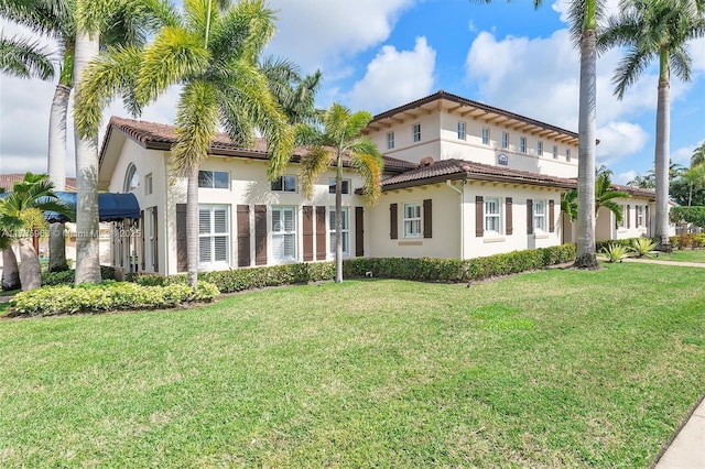 mediterranean / spanish home with a front lawn