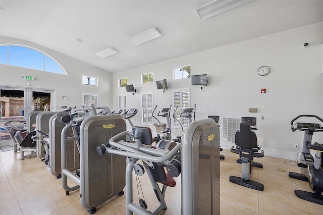 workout area with high vaulted ceiling and light tile patterned floors