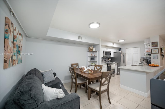 dining room featuring sink and light tile patterned floors