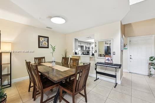 dining area with baseboards and light tile patterned flooring